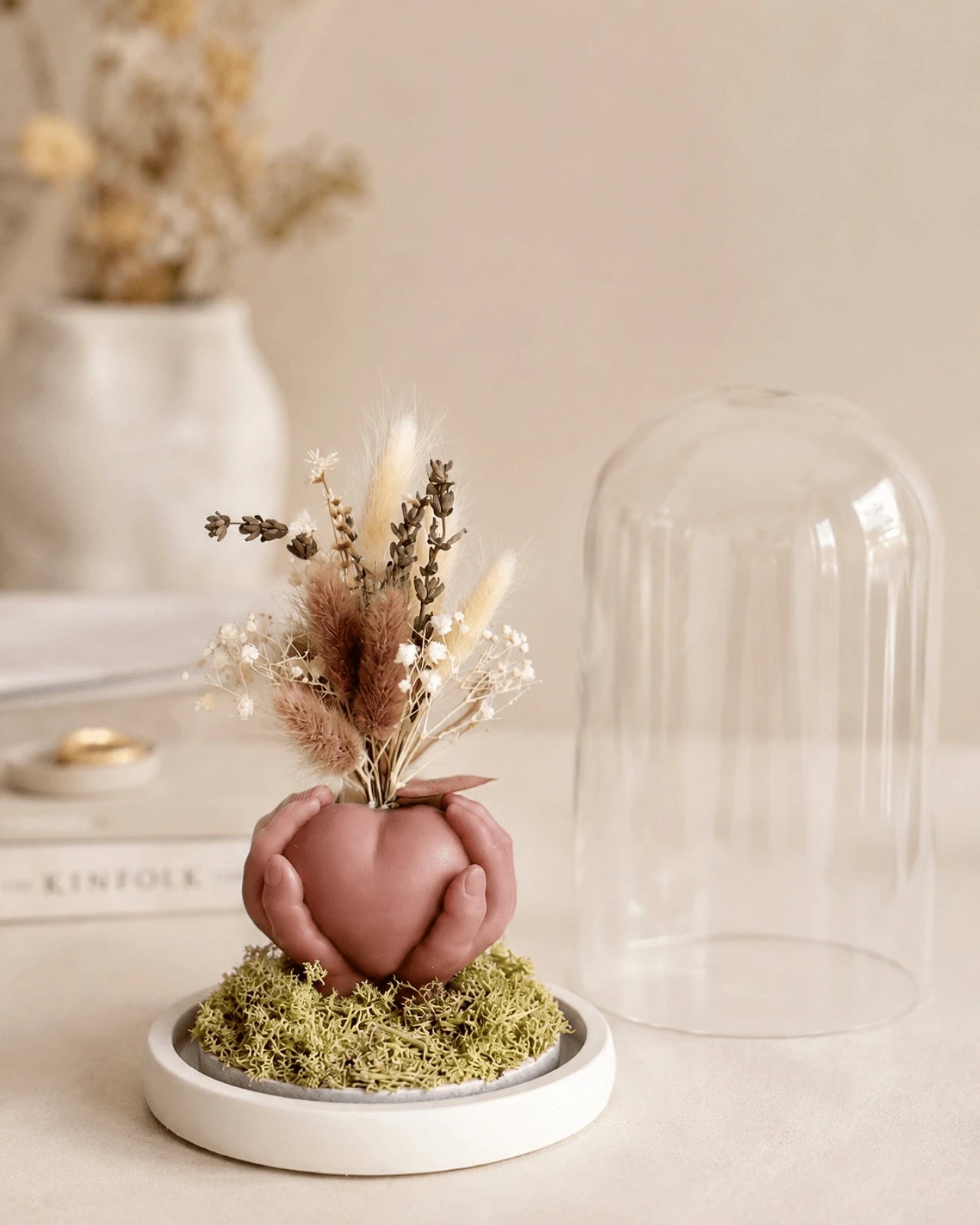 Carinho: composizione di fiori secchi in vaso di cera a forma di cuore sorretto da mani con campana di vetro e base di legno - Io Sono La Luce Roma | Colore mocha mousse marrone