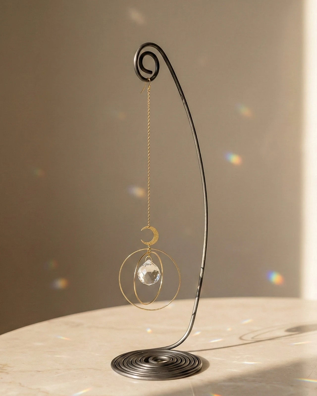 Heliophilia - Acchiappasole feng shui artigianale che crea arcobaleni di luce | Versione da tavolo con supporto in fil di ferro - suncather con cristallo e simbolo in ottone a forma di universo