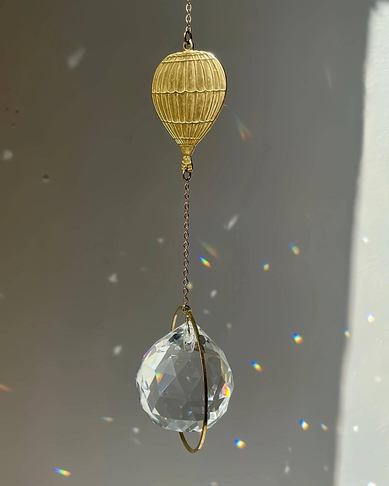 Suncatcher Heliophilia - Acchiappasole feng shui artigianale che crea arcobaleni di luce con cristallo sfaccettato e simbolo in ottone mongolfiera