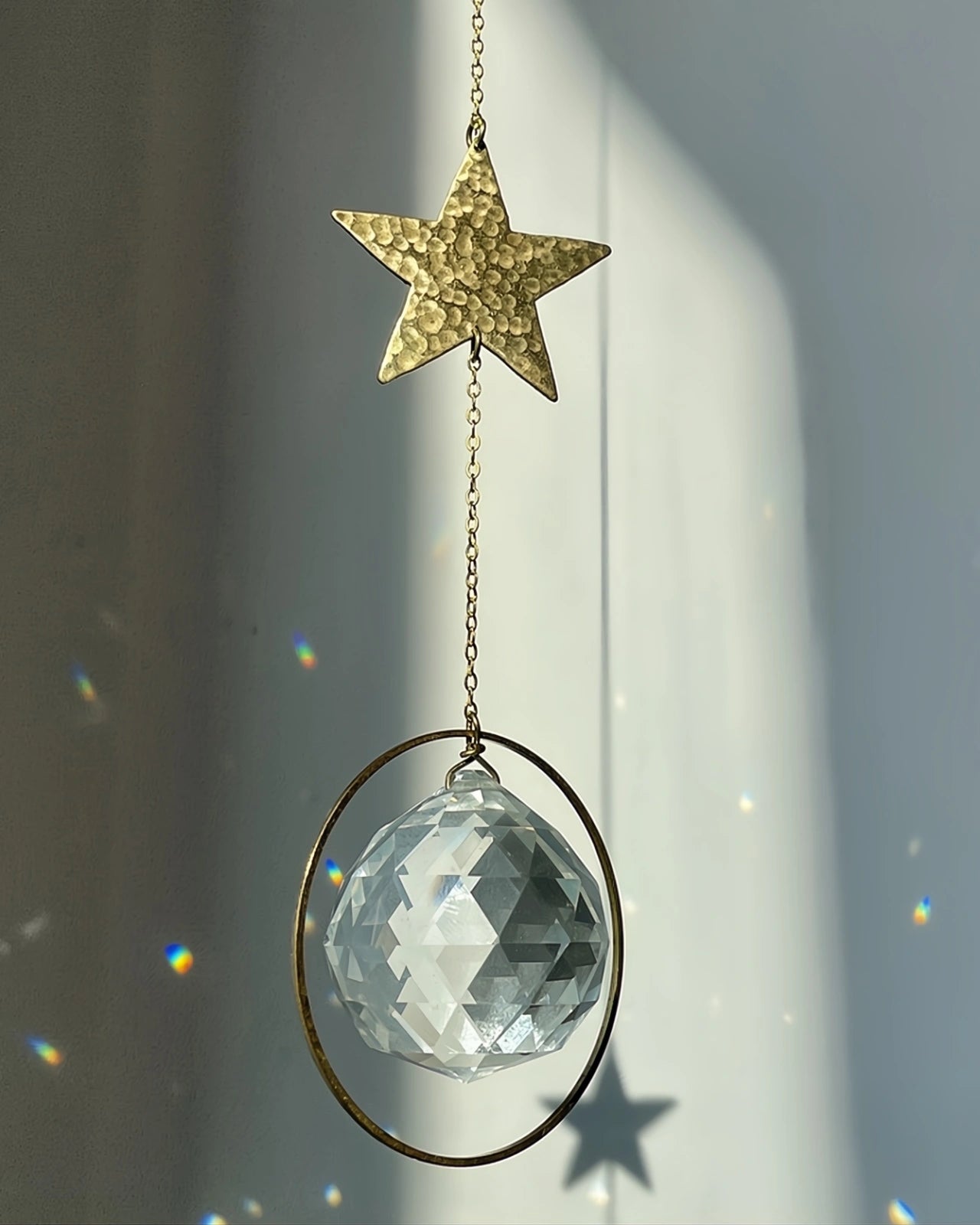 Suncatcher Heliophilia - Acchiappasole feng shui artigianale che crea arcobaleni di luce con cristallo sfaccettato e simbolo in ottone stella