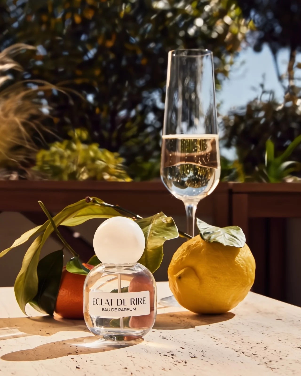 Flacone di profumo Eclat de Rire di Orbe de Memoire con tappo sferico, profumo agrumato e frizzante con note di champagne e l'89% di ingredienti naturali