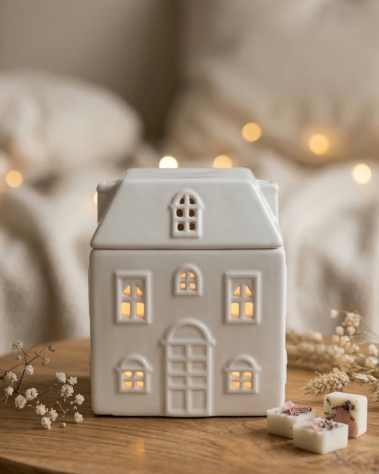 Bruciatore ceramica casetta Akari No Ie acceso — luce soffusa che filtra dalle finestre