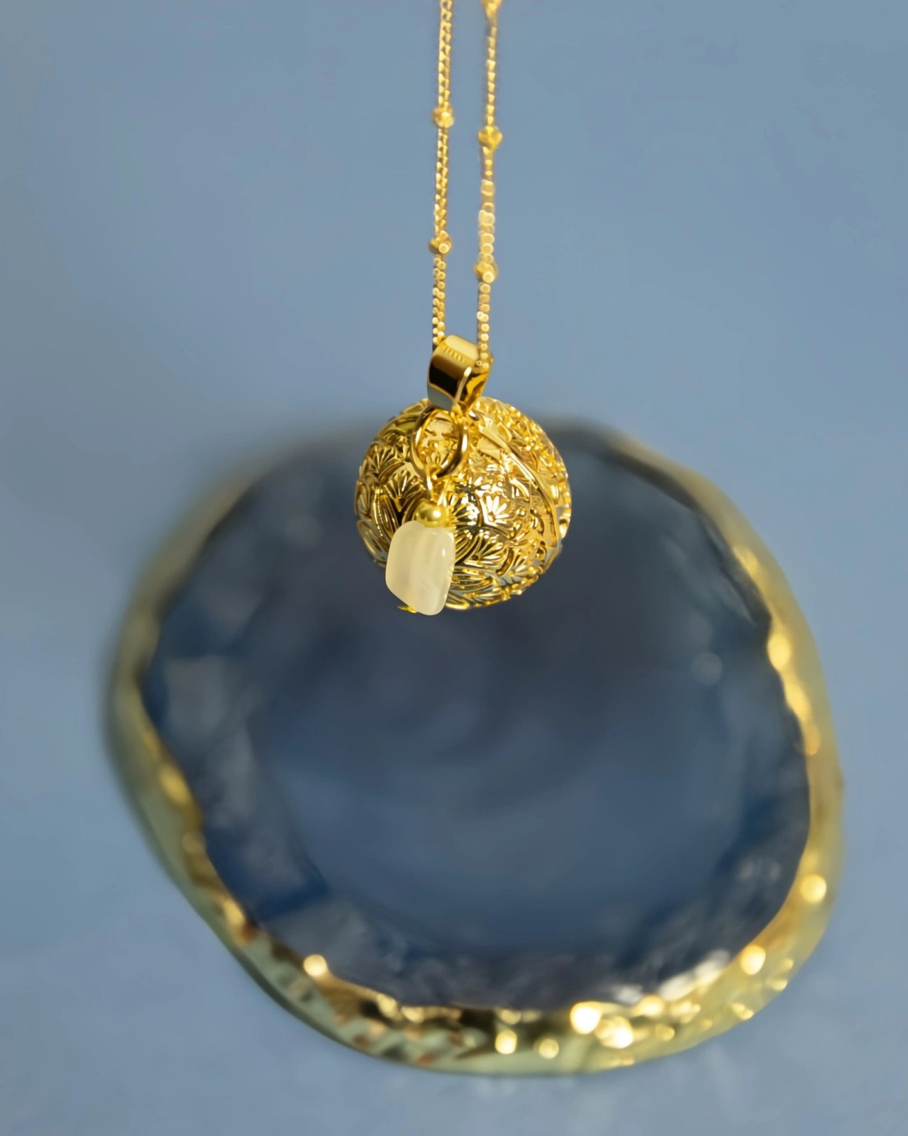 Collana Chiama Angeli, in acciaio placcato oro, realizzata artigianalmente in Francia, con pietra di luna e ciondolo Bola con mandala inciso