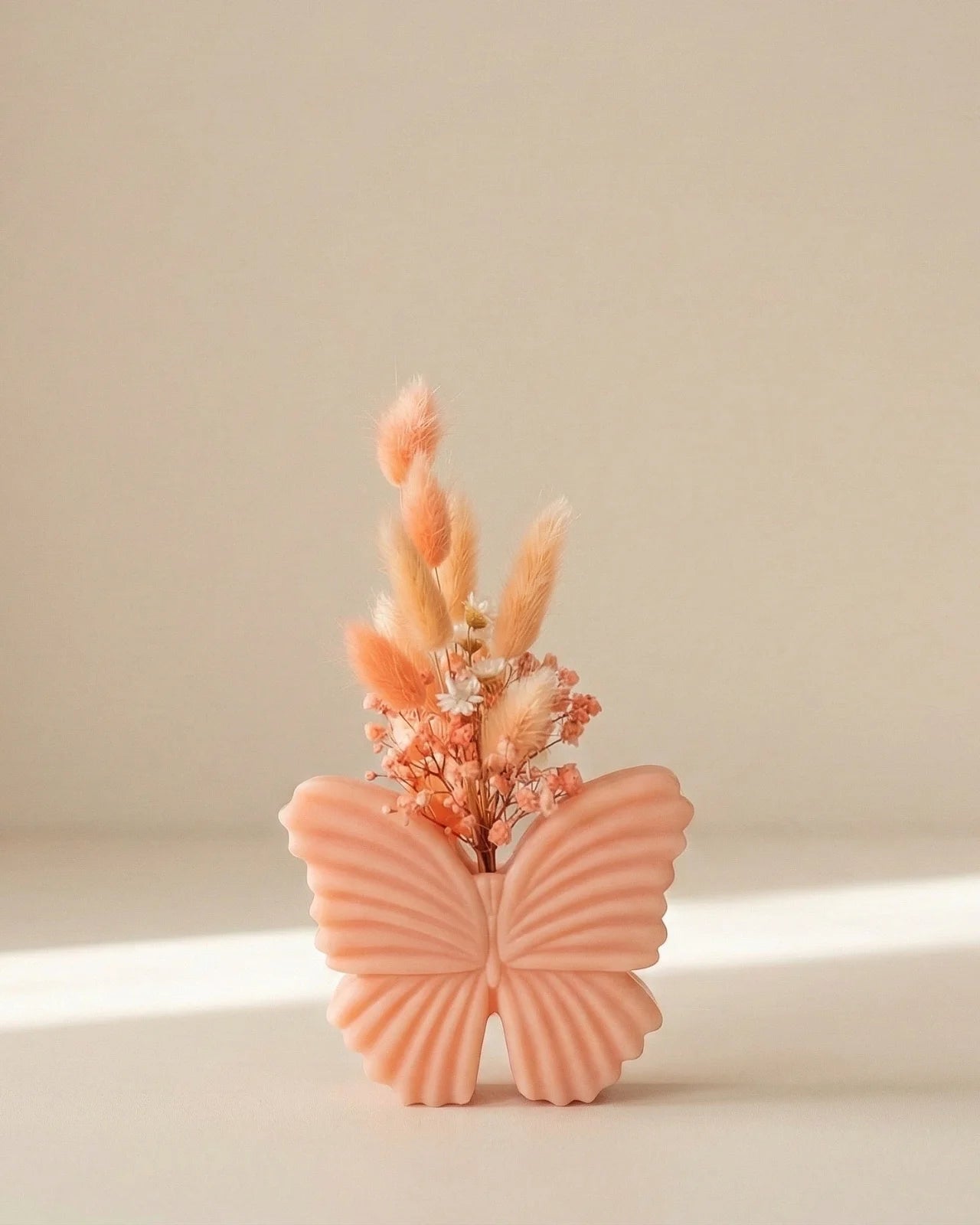 Vaso di cera a forma di farfalla con bouquet di fiori secchi e stabilizzati, creazione artigianale simbolo di rinascita color pesca