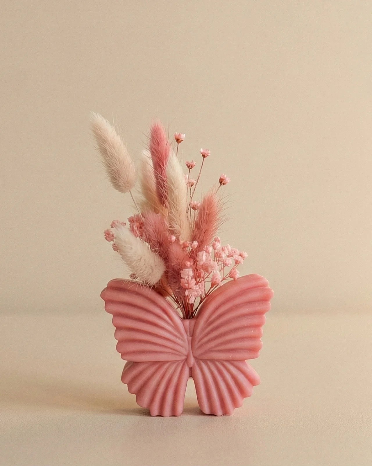 Vaso di cera a forma di farfalla con bouquet di fiori secchi e stabilizzati, creazione artigianale simbolo di rinascita color rosa flamingo