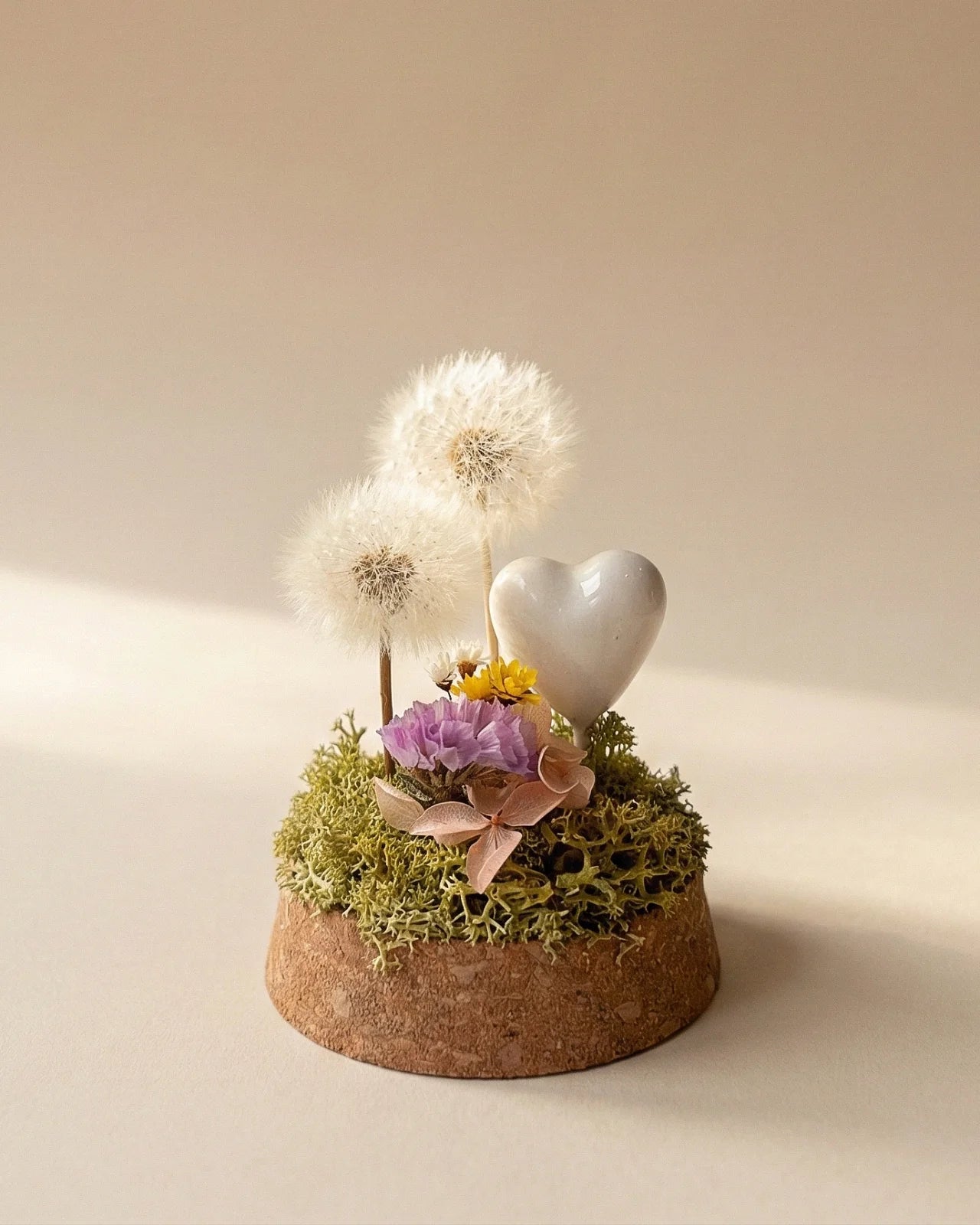 dettaglio composizione di due soffioni stabilizzati con glixie, statice ed ortensia stabilizzati su letto di muschio verde stabilizzato