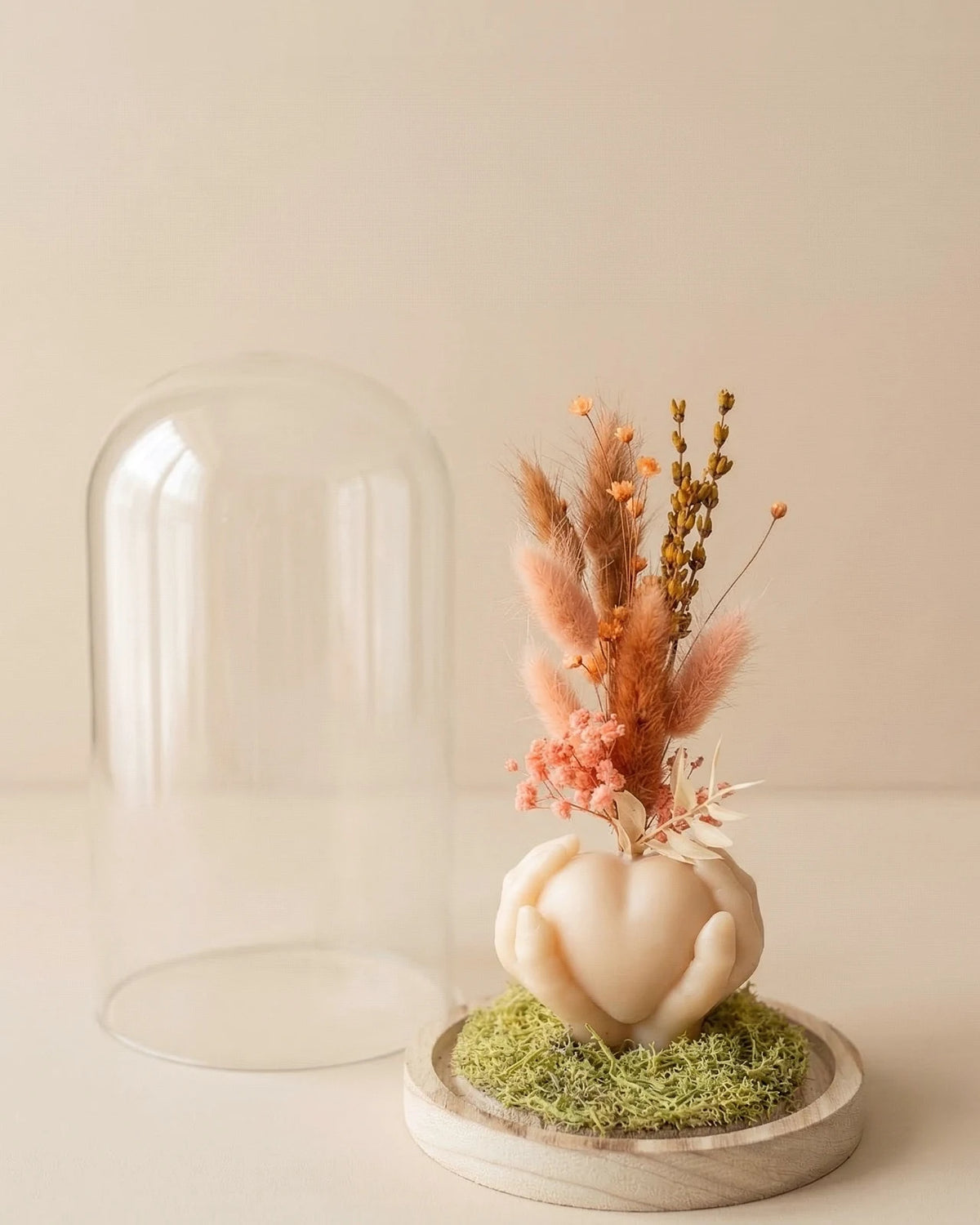 Vaso di design artigianale in cera a forma di cuore sorretto da mani con fiori secchi e stabilizzati, fatto a mano atelier Roma | Colore grano