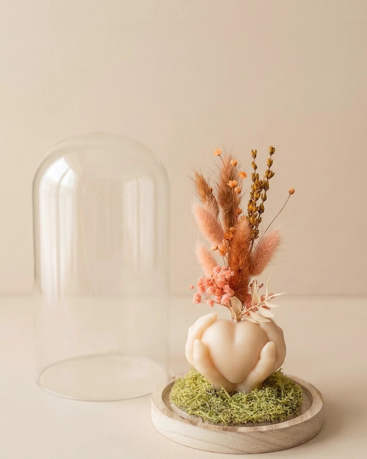 Vaso di design artigianale in cera a forma di cuore sorretto da mani con fiori secchi e stabilizzati, fatto a mano atelier Roma | Colore grano