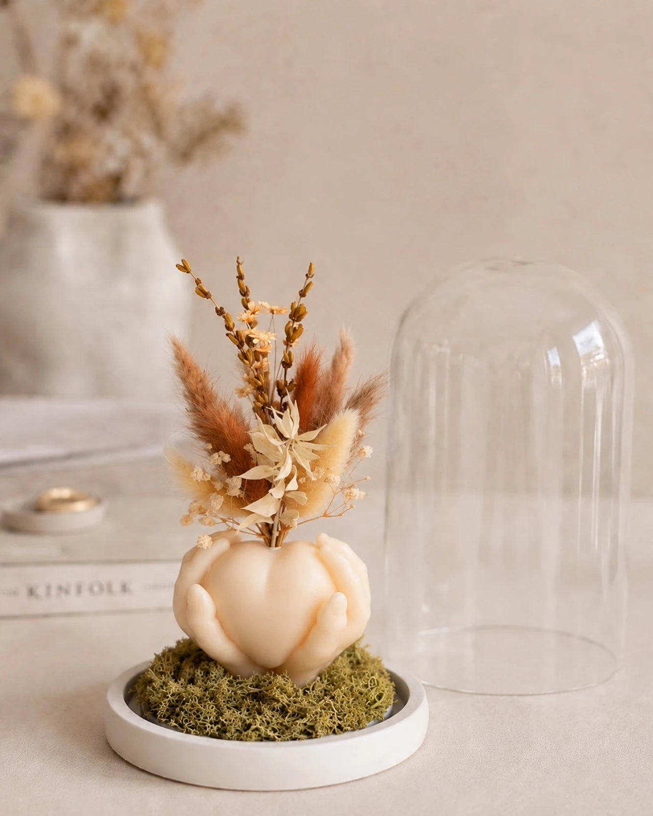 Carinho: composizione di fiori secchi in vaso di cera a forma di cuore sorretto da mani con campana di vetro e base di legno - Io Sono La Luce Roma | Colore grano