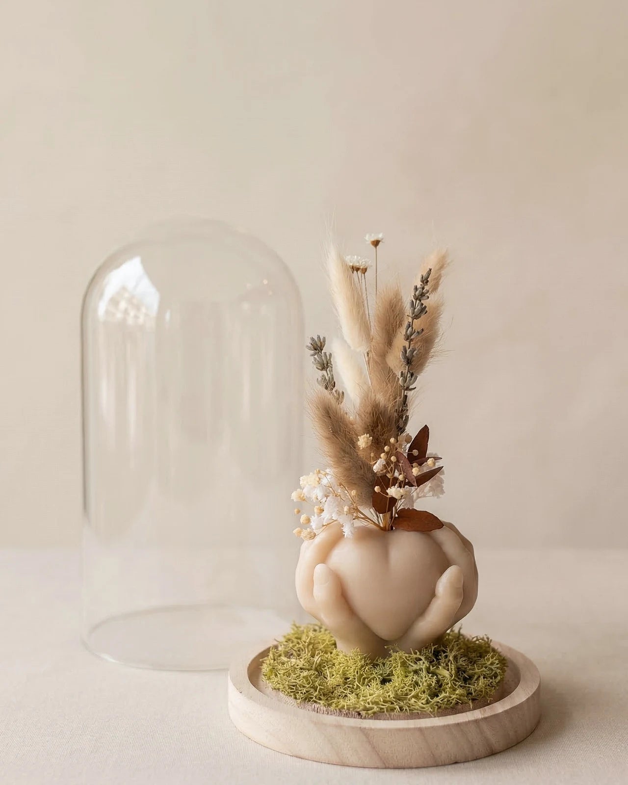 Vaso di design artigianale in cera a forma di cuore sorretto da mani con fiori secchi e stabilizzati, fatto a mano atelier Roma | Colore sabbia