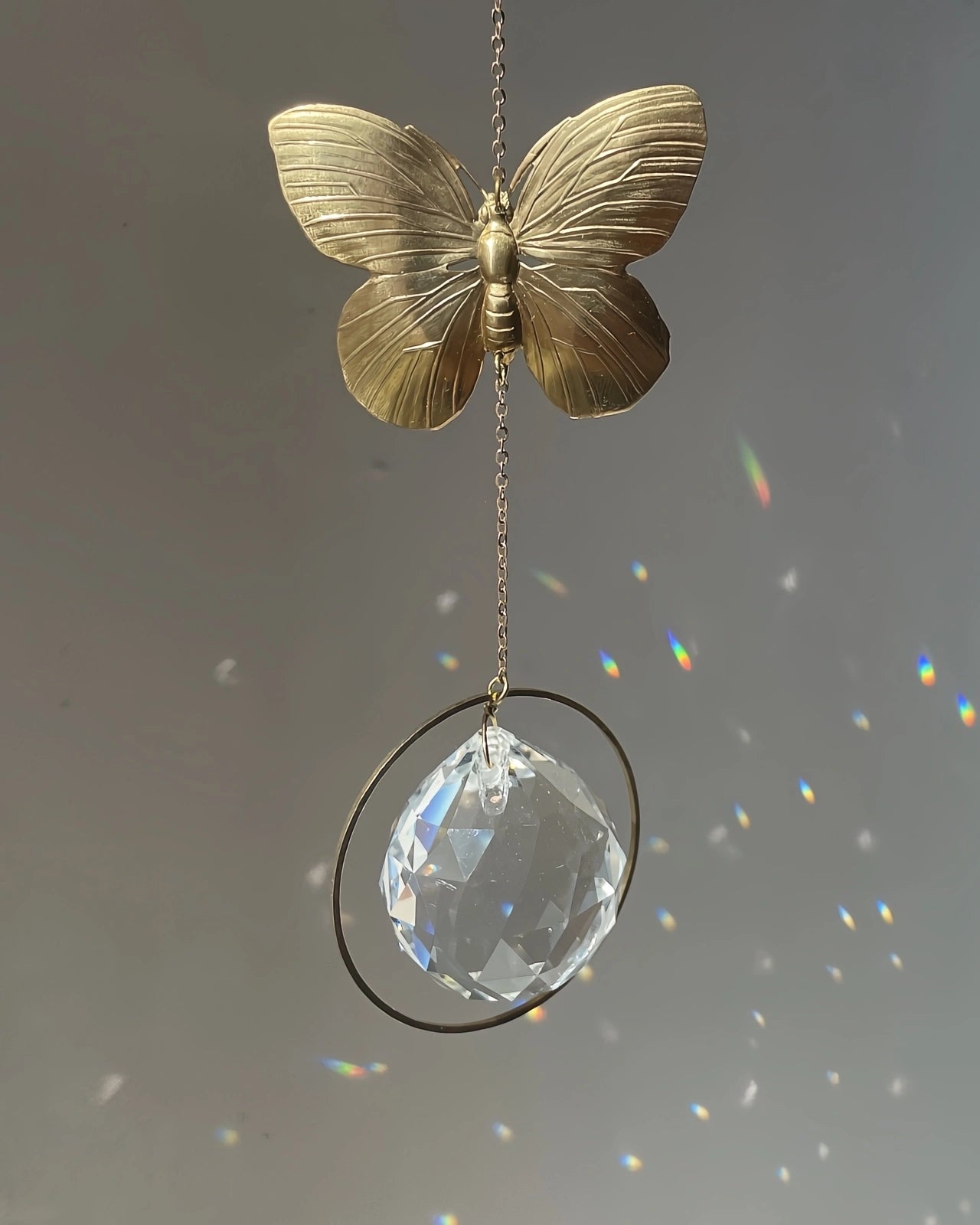 Suncatcher Heliophilia - Acchiappasole feng shui artigianale che crea arcobaleni di luce con cristallo sfaccettato e simbolo in ottone farfalla
