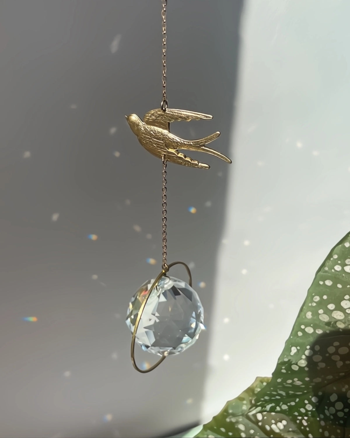 Suncatcher Heliophilia - Acchiappasole feng shui artigianale che crea arcobaleni di luce con cristallo sfaccettato e simbolo in ottone rondine