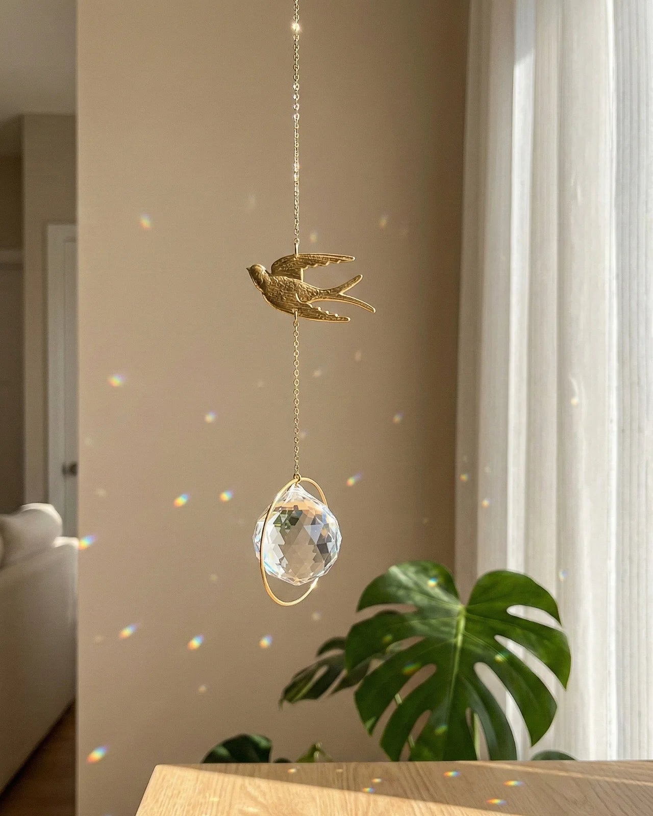 Suncatcher Heliophilia - Acchiappasole feng shui artigianale che crea arcobaleni di luce con cristallo e simbolo in ottone a forma di rondine