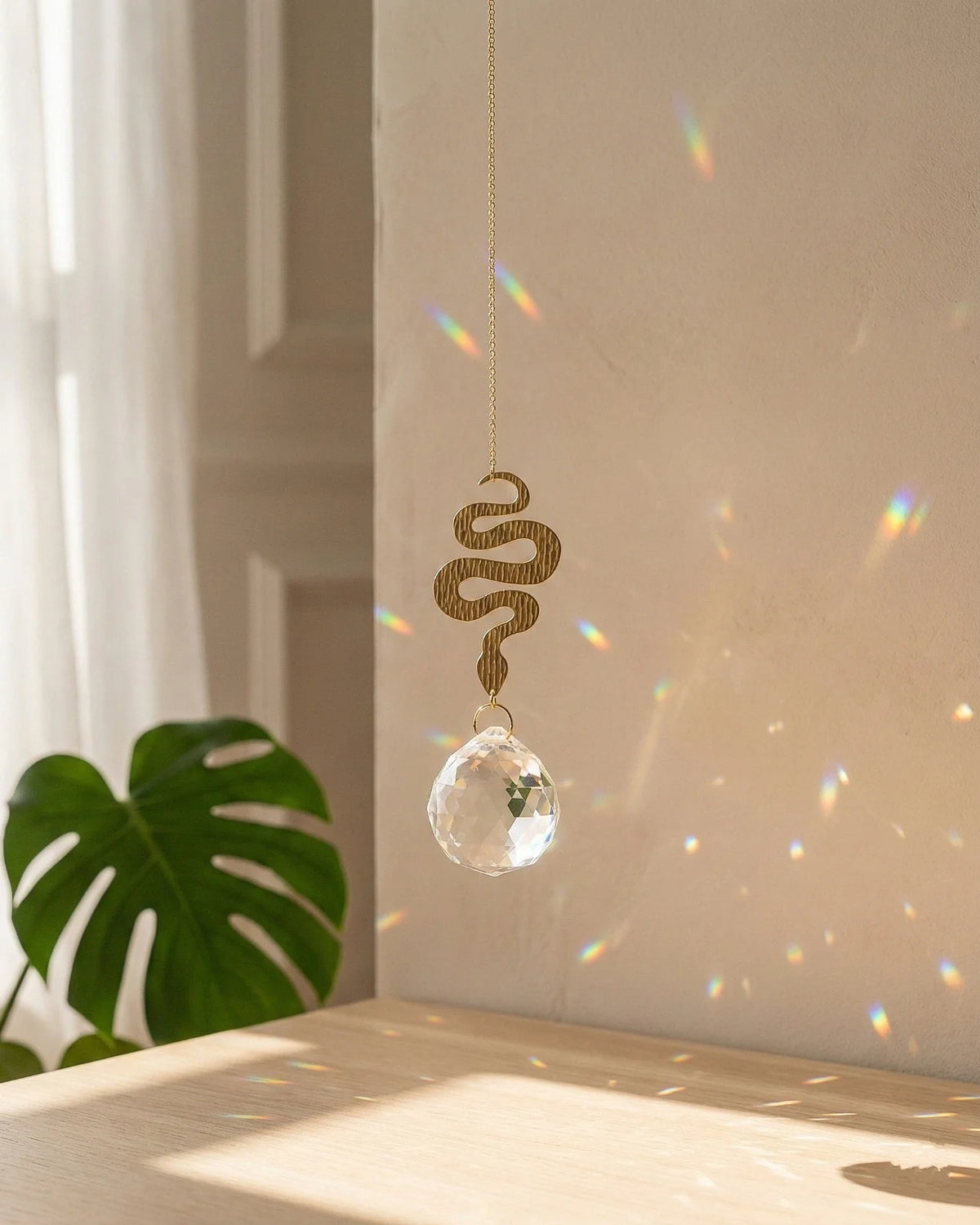 Suncatcher Heliophilia - Acchiappasole feng shui artigianale che crea arcobaleni di luce con cristallo e simbolo in ottone a forma di serpente