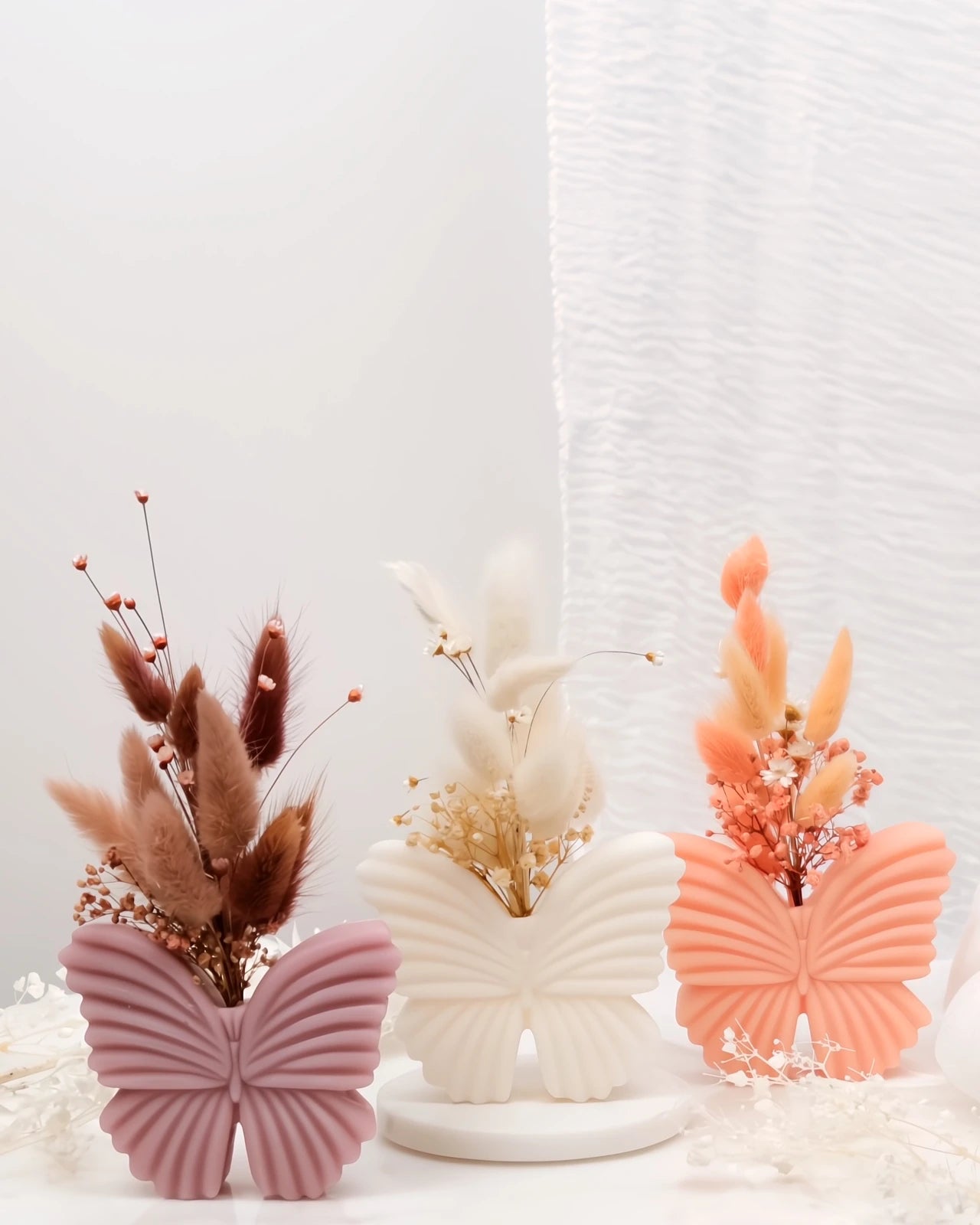 vaso di cera profumato a forma di farfalla con composizione fiori secchi e stabilizzati per un tocco bohémien in case japandi e moderne 