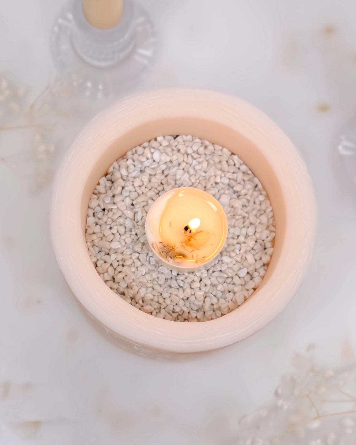 vista zenitale del vaso con sassolini bianchi e tealight accesa al centro