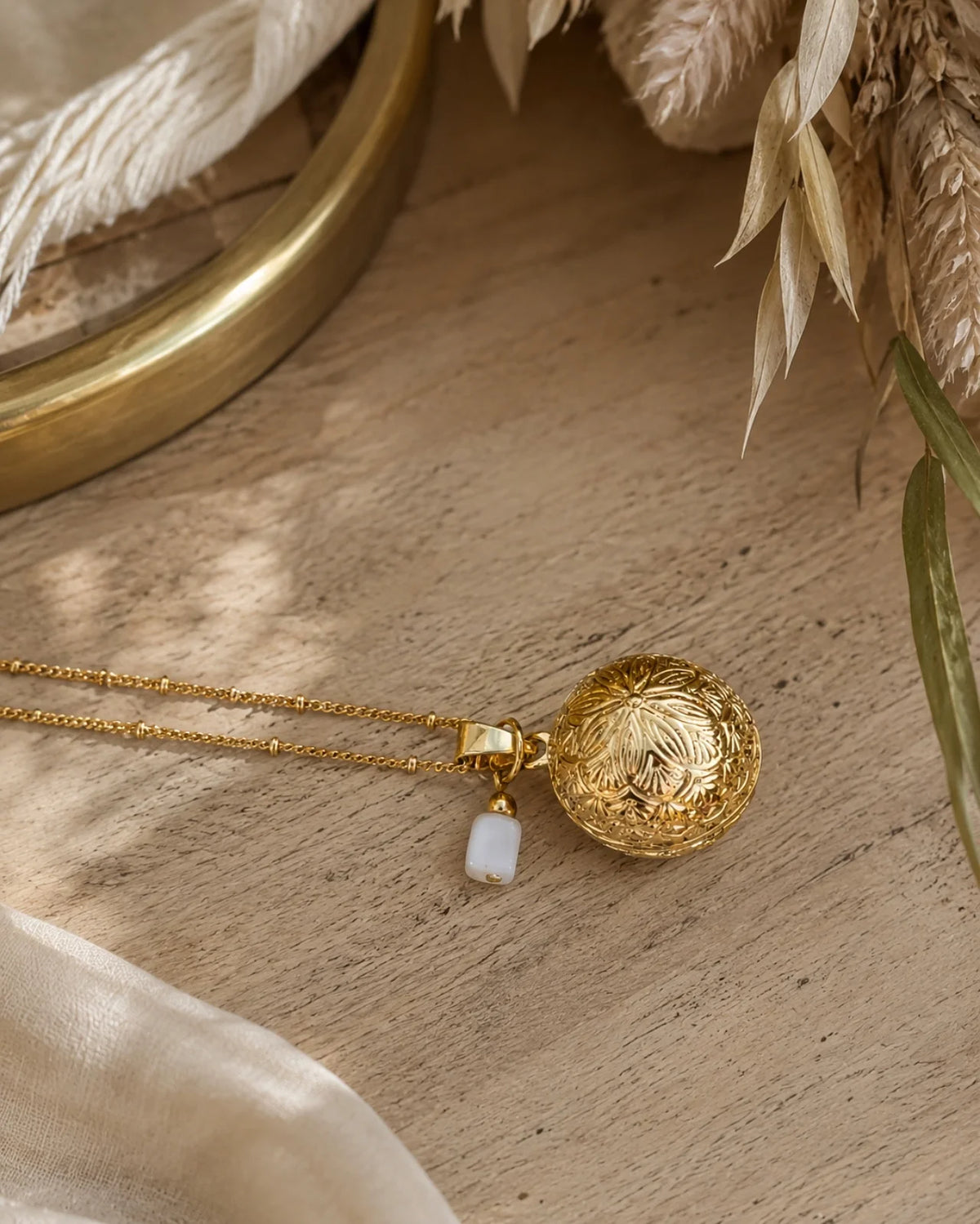 Collana Chiama Angeli, in acciaio placcato oro, realizzata artigianalmente in Francia, con pietra di luna e ciondolo Bola con mandala inciso