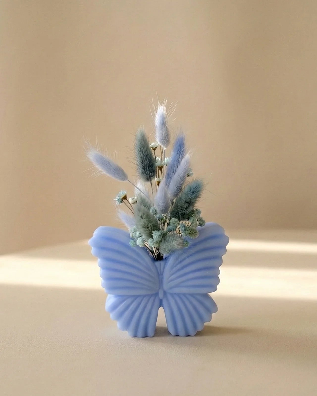 Vaso di cera a forma di farfalla con bouquet di fiori secchi e stabilizzati, creazione artigianale simbolo di rinascita color carta da zucchero