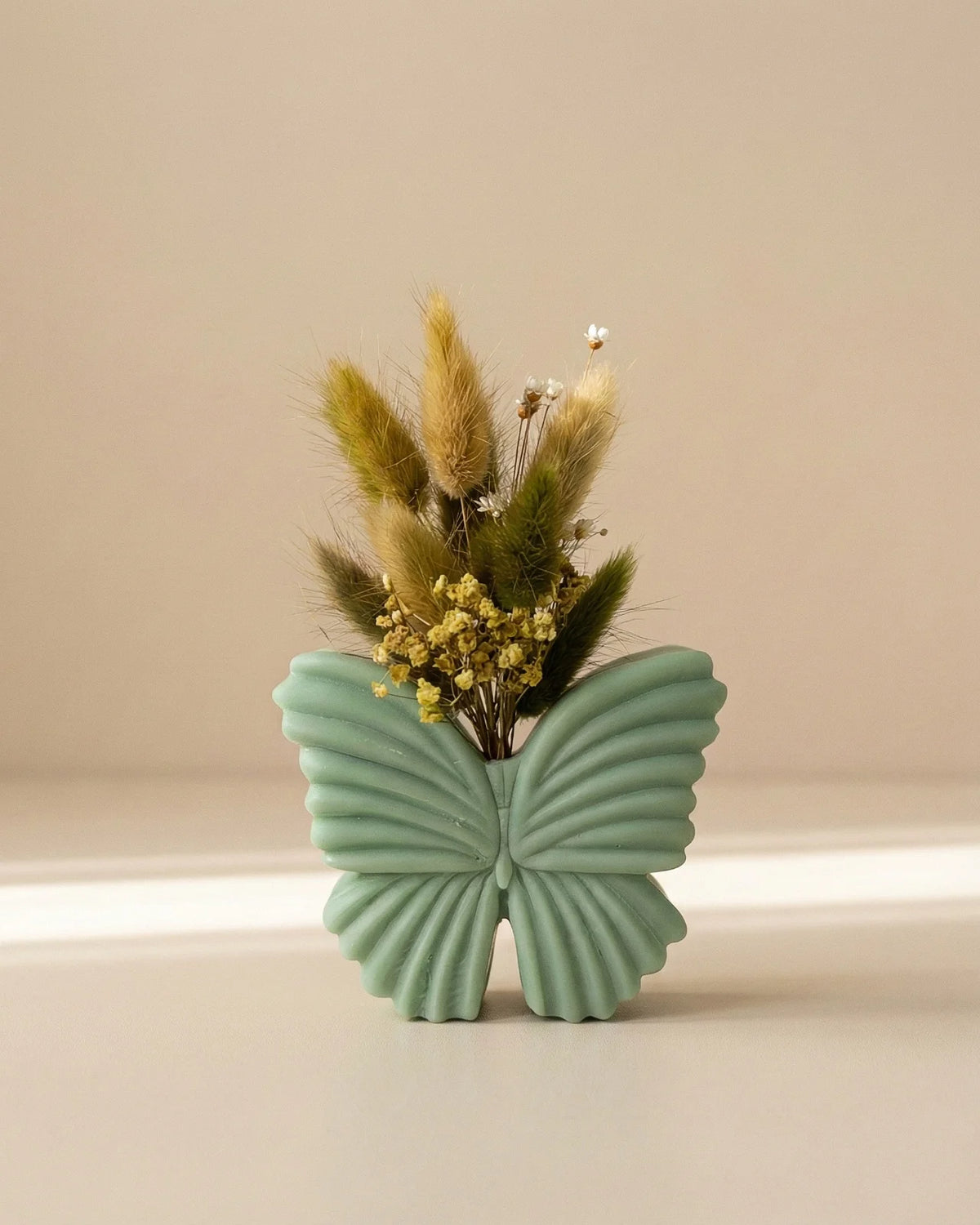 Vaso di cera a forma di farfalla con bouquet di fiori secchi e stabilizzati, creazione artigianale simbolo di rinascita color verde matcha