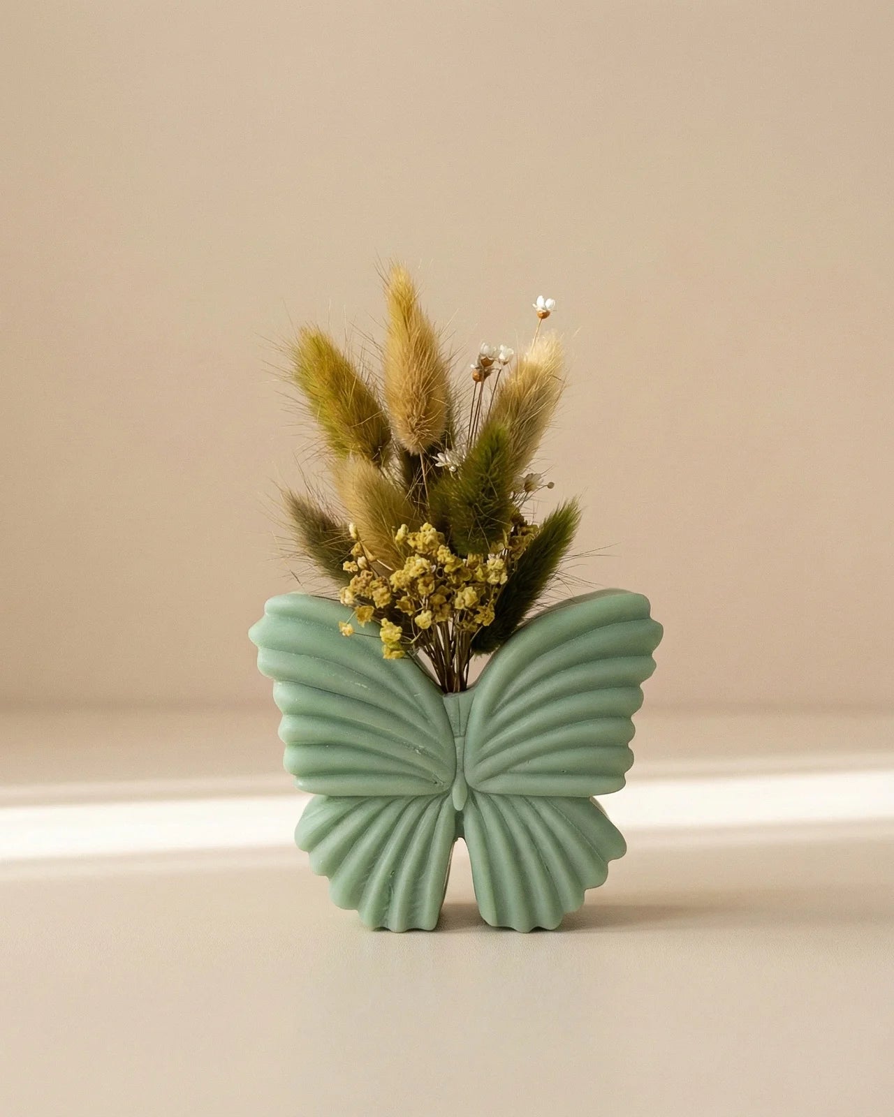 Vaso di cera a forma di farfalla con bouquet di fiori secchi e stabilizzati, creazione artigianale simbolo di rinascita color verde matcha