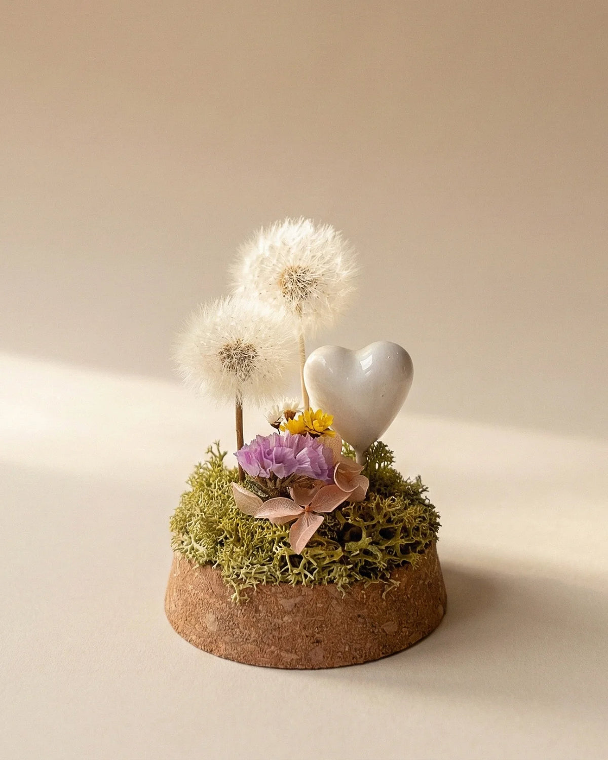 dettaglio composizione di due soffioni stabilizzati con glixie, statice ed ortensia stabilizzati su letto di muschio verde stabilizzato